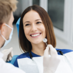 Smiling woman during cosmetic dental checkup professional dentist examining teeth in modern dental clinic